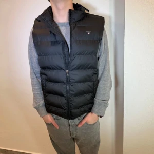 HELT NY Svart dunväst från GANT - HELT NY svart väst från Gant || storlek 170cm (15år) || Mitt pris 799kr || modellen på bilden är 170cm och väger 60kg || tveka inte på att höra av dig vid frågor 