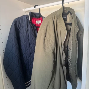 Olivgrön bomberjacka från Rut&Circle - Båda för 80kr Snygg olivgrön bomberjacka från Rut&Circle med klassisk ribbad krage och muddar. Jackan har dragkedja framtill, fickor med tryckknappar och en ärmficka med zip. Perfekt för dig som gillar streetstyle och vill ha en chill look.