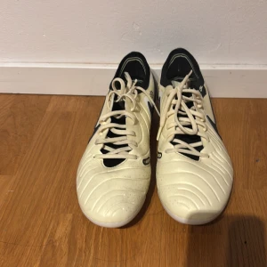Nike vita fotbollsskor med snörning - Säljer ett par stilrena fotbollsskor från Nike i vit färg med svarta detaljer. Nästan helt oanvända