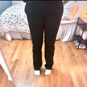 Svarta kostymbyxor med raka ben - Svarta kostymbyxor som är utsvängda och med låg midja. Sitter perfekt för mig som är 165cm och vanligsvist har strl 36-38. Ytterbenslängd: 102cm. Dom har lite utstickande trådar på baksidan (7de bilden) vid vaden men det är inget som syns när dom är på. Knappt använda bara tvättade