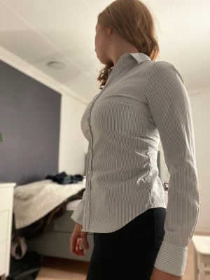 Randig Gant skjorta - Grå/vit randig Gant skjorta. Storlek 32. Använd fåtal gånger och jag har växt ur den. Nypris 1000 kr, mitt pris 475 kr. Köparen står för frakten!