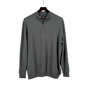 Grå stickad tröja med dragkedja - Grå stickad tröja från Hugo Boss med dragkedja.   Plagget har en normal passform.   Mått, i cm: Bröst: 134 Midja: 132 Stuss: 116 Rygglängd: 75 Ärmlängd: 69