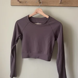 Tränings-topp Ryvelle - Oanvänd croppad tränings-topp från Ryvelle. Nypris 500:-. Lilabrun i färgen🤎💜