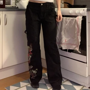 Byxor med tryck  - Svarta byxor med tryck/mönster längst ner på benets ena sida 💕