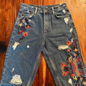 nästintill oanvända jeans med fint blommigt mönster. lösare passform.