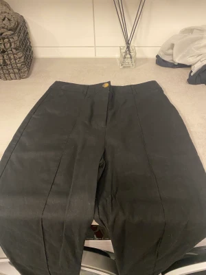 Asos byxor, hög midja, strl 38 - Svarta Linnebyxor från Asos i strl 38. Hög midja, två fickor fram och en dekorativ söm längs med benet på framsidan. 