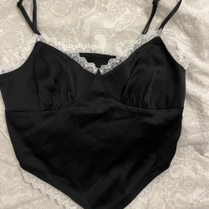 Svart linne - Svart linne med vit spets. Dragkedja på sidan och ljuster bara band 