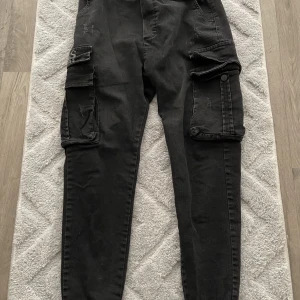 Hugo boss cargobyxor för herr - Jag fick det här som present av en av mina kompisar på mitt födelsedag. Det har blivit för små för mig, så jag vill sälja dom och spendera pengarna på ett par nya cargobyxor. Jag har haft dom i cirka 10 månader. Dom är fortfarande i en väldigt bra skick. 
