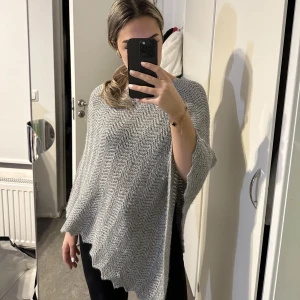 Super fin grå glittrig poncho  - Superfin glittrig poncho att bara slänga över en outfit.  Bra skick, använd fåtal gånger!