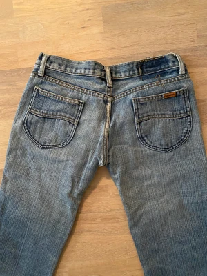 2000-talet jeans  - 2000 -talet jeans YtoK  Snygg slitning  Låga i midjan  Mått i midja 84cm Innerbenslängd 74cm  Bootcut