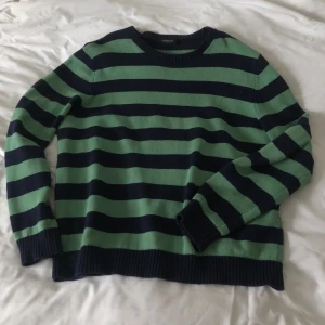 Randig stickadtröja strl L - Stickad tröja i storlek L. Grön och mörkblå randig. I gott skick, men dm:a gärna vid frågor eller funderingar! Köparen står för frakt 