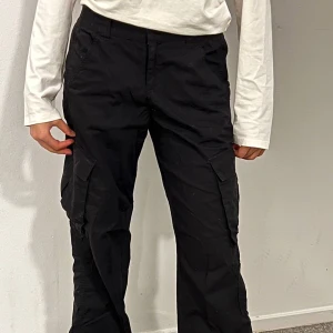 Cargo - Här är ett par svarta cargo byxor. Den är helt svårt med flera fickor.  Obs! Kunden står för frakten. 