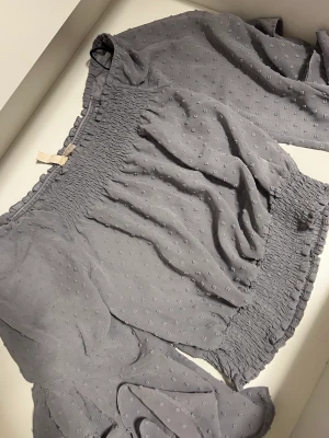 Blus - Fin blus i grå färg. Använd 1 gång. 