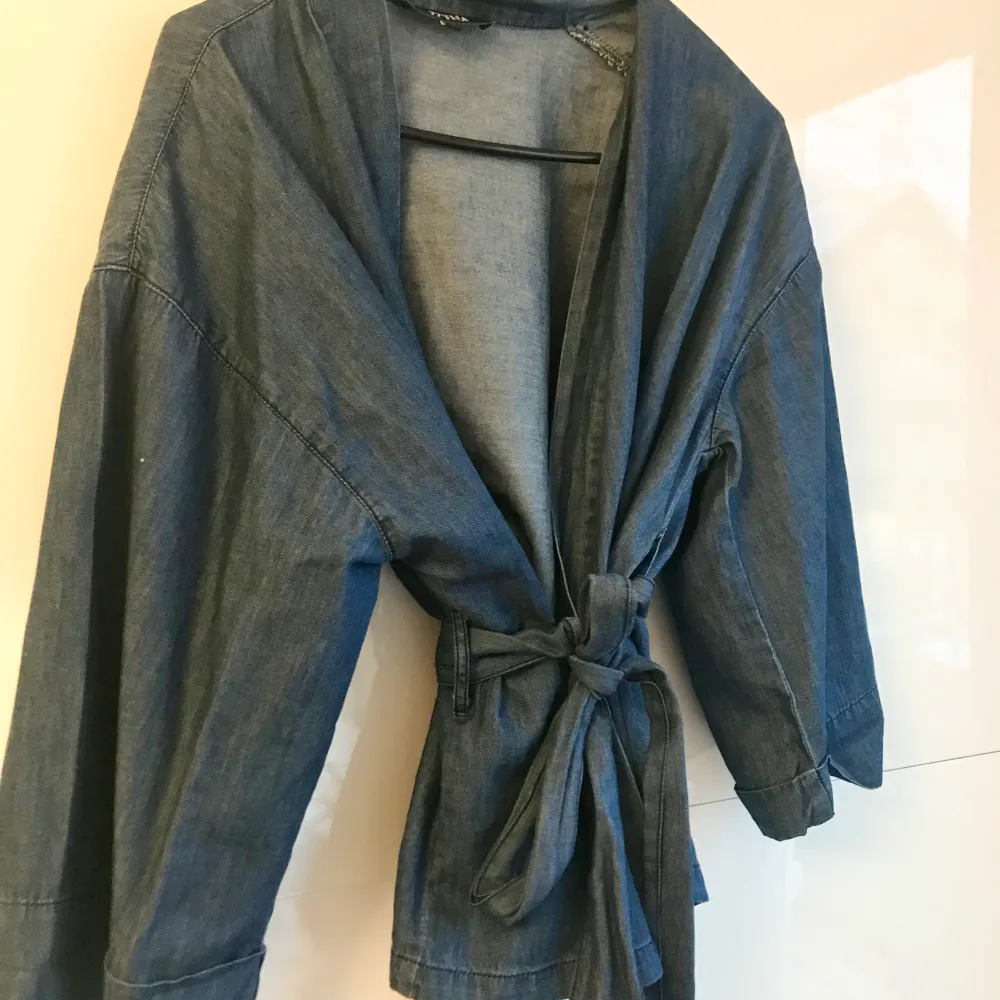 Fin blus/kimono i jeanstyg inköpt på Bubbleroom. Storlek 34. Använd ett fåtal gånger så inga tecken på användning.   100 % bomull. Blusar.