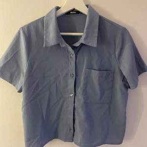 En kort blå skjorta från Bikbok.  Använd 1-2 gånger. 