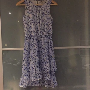 Sommarklänning - Jag säljer den pga att den är för liten. Klänningen har volanger längst ner och knäpps med en knapp på ryggen. 