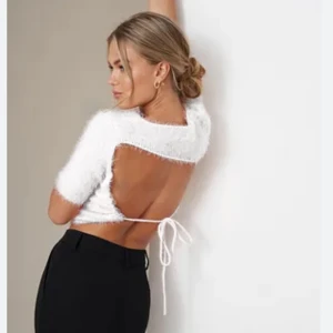 Topp - Vit crop top från Hanna Schönbergs collection med NAKD. Öppen i ryggen och i ett ”lurvigt” material. Inte genomskinlig alls! Använd en gång. Kan mötas upp i Jönköping eller Vaggeryd annars tillkommer fraktkostnad 🤍