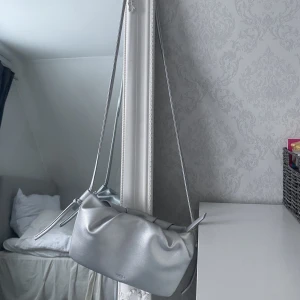 Väska - Silvrig axelremsväska som är skitcool men inte kommer  till någon användning:/