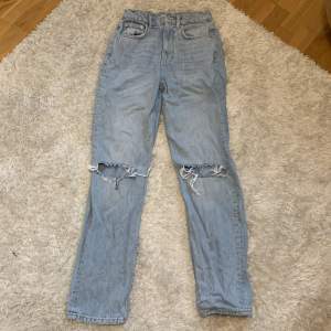 Ljusblå jeans från Gina Tricot med hål på knäna. Storlek 34 i använt skick 100 kr + frakt 
