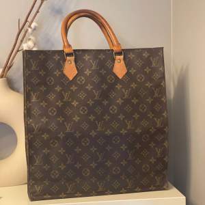 En Sac Plat från Louis Vuitton i monogram canvas.  Fint vintage skick. Välbehållen canvas och fin patina. Fint skick på insidan. Enda stället där det är aning slitet är i de fyra nedre hörnen samt i en överkant där några av stygnen släppt. 