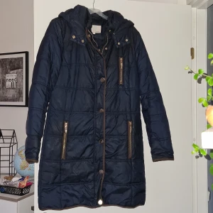 Fransa vinterjacka S - Knälång vinterjacka, mörkblå med gulddetaljer, storlek S