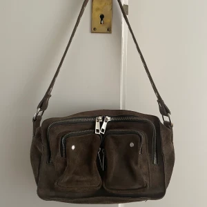 Brun Nunoo väska - Riktigt snygg brun Nunoo väska, köpt här på Plick men ska snart resa bort och får inte med mig alla mina väskor🥲 Inga märken/skador!