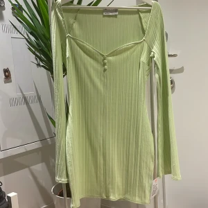 Ljusgrön klänning med utsvänga ärmar - Lite ljusare än på första bilden. Endast provad, lappen finns kvar i sidan. Köparen står för frakten.