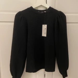 Volang tröja - Tröja från NA KD som har volanger på ärmarna!! Den är i storlek XS och aldrig andvänd, prislappen finns kvar. Kontakta mej för fler bilder. Jag säljer den för 99kr+ frakt, orginalpris 399kr!!