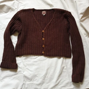 Croppad kofta - Brun kofta i croppad modell. Älskar den men den är lite för stor på mig. Bild 1 stämmer bäst med färgen. Knappar i trä. Storleksmarkerad som M. Sitter som en s/liten m
