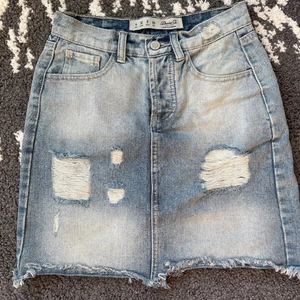 Jeans kjol - Ljusblå jeanskjol, superfin med slitningar. Storlek 32