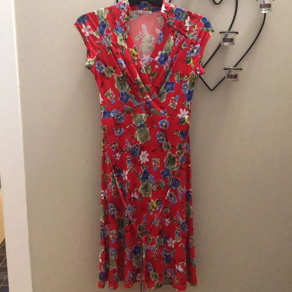 En röd blommig sommar klänning från Stockholms klänningafabrik, använd 1 gång, nyskick, nypris 1399 ✨Frakt +45✨. Klänningar.
