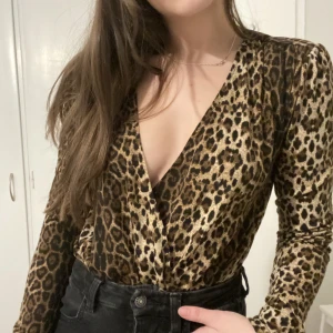 Leopard body från NAKD - Leopard body från NAKD, storlek XS. V ringad och har vadderade axlar. Säljer för 50 kr köparen står för frakten 😊