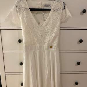 Så snygg vringad vit klänning med spets från Chiara Forthi! Köpte den till en skolavslutning men använde den aldrig, prislapp sitter kvar! Köpt på bubbleroom. Perfekt till studenten, skolavslutningen osv, storlek L. Originalpris: ca 599