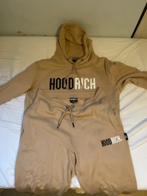 Hoodrich dress - Beige hoodrich dress Hoodien är storlek M och byxorna storlek L   Det finns en liten fläck på luvan Priset kan diskuteras Köparen står för frakt!!   Kvitto finns!!