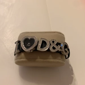 D&G klocka I love Dolce & Gabbana  - Dolce & Gabbana D&G Svart/läder  Mått: 23-22mm Tjocklek: 10mm Modell: 3719251671 Nypris 4020kr Är behov av nytt batteri