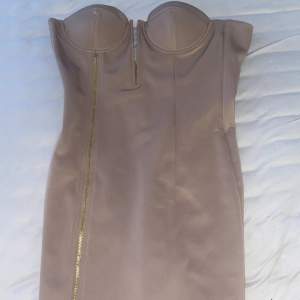 en kort klänning i färgen beige med dragkedja på, aldrig använd. sitter jättefint men såg lite konstigt ut på mig :)