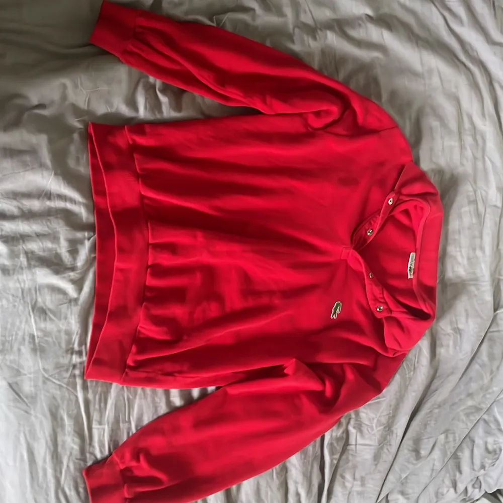 Jättefin röd Lacoste tröja med krage och knappar. Man kan antingen ha knapparna uppknäppta eller  stängda beronde på hur man vill det ska se ut. (Jag har storlek s, sitter skitsnyggt oversized). Tröjor & Koftor.