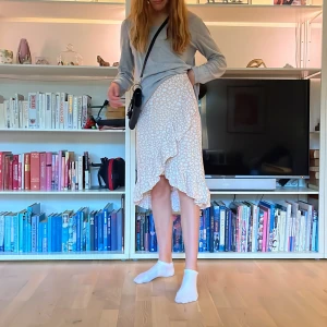 Kappahl beige omlottkjol blommor - Skön beige midi-omlottkjol med volanger med vita blommor från Kappahl. Strl 146/152 men passar xs och s. Är 165 cm och den kostade runt 300💕⚡️