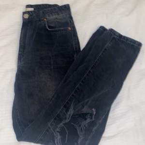 Ett par svarta jeans från Gina tricot i storlek 34/xs. Använt ett par gånger men i bra skick. Mid waist med hål vid knäna och passar mig bra som är runt 155/160. Säljer för 150kr. 