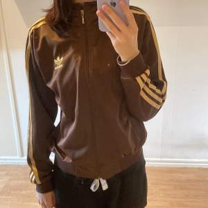 Brun och guldig kofta från adidas! Lappen är bortklippt så ser ingen storlek men skulle säga S eller M! Fint skick, nästan aldrig använd. Pris - Högsta budet + frakt! Avslutas torsdag 13:e oktober 18:00:)