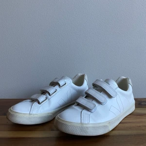 Veja vegan leather sneakers size 38 - White Veja vegan leather sneakers in fair condition. They haven’t been worn too much, but you know white shoes in Stockholm never stay perfect! Velcro closure make it easy to slip in and out. Thin scuff mark on left shoe tongue, can’t see it when shoe on.
