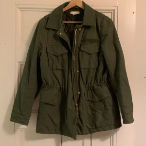 Grön Jacka  - En militärgrön tjock jacka ifrån HM. Storlek 36. Band i midjan som går att justeras. Helt oanvänd. 250kr + frakt (cirka 50kr)