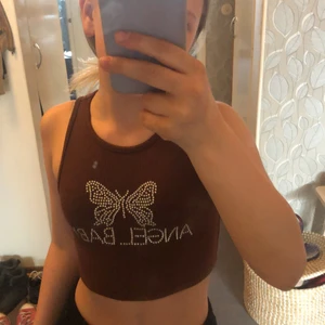 Brunt kort magtröja stl xxs  - En brunt kort magtröja där det står angel baby på. Den  är från Shein, nästan aldrig andvänt. Den är kort men stretchig. Den är i bra skick och ingen av rhinestonesen har ramlat av vad jag vet.