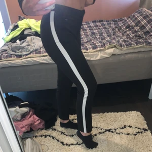 Kostymbyxor strl M - Svarta kostymbyxor med vita detaljer på varje sida. De sitter jätte fint och är sköna att ha på sig. Nyskick endast använt 2 gånger.