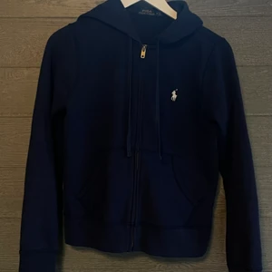 Ralph Lauren Zip strl: M/S - Säljer denna mörkblåa Ralph Lauren Zip hooiden då den för ett bra tag sedan inte längre passade, den är lite liten i storlek så passar nog någon med storlek S, den är bara använd ett fåtal gånger och välskött utan fläckar, trasiga sömmar m.m! Skicka PM för mera bilder och mera info!