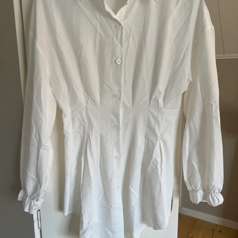 En lite längre vit skjorta från shein, smalnar in vid midjan. Aldrig använd.. Skjortor.