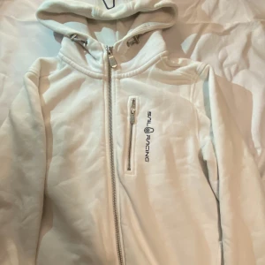 Sail racing huvtröja - En vit sailracing hoodie i storlek 160, skulle nog säga att storleken motsvarar xs/s. Använd ca 1 gång. Kan mötas upp i gbg/skövde :) köpt för 999!