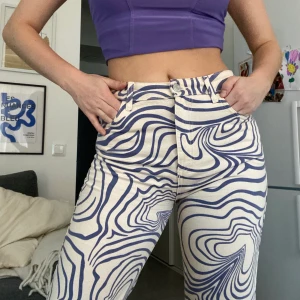 Mönstrade jeans  - Beigea jeans med lila mönster. Använda en gång. 