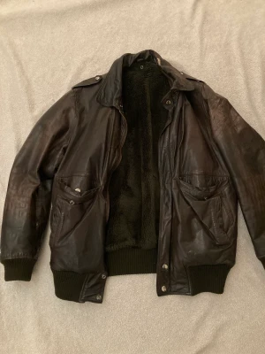 Läderjacka - Fodrad läderjacka i äkta skin, fint skick förutom en liten reva vid kragen som jag märkte först när jag tog bild på den. Sitter oversized på mig som är XS