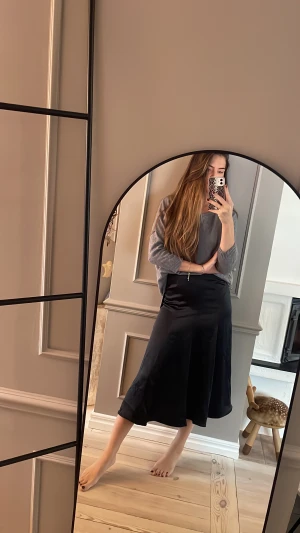 Svart sidenkjol med fint fall - Så fin kjol med fantastiskt fall, tyvärr är den för liten. Aldrig använd, nypris 600kr.